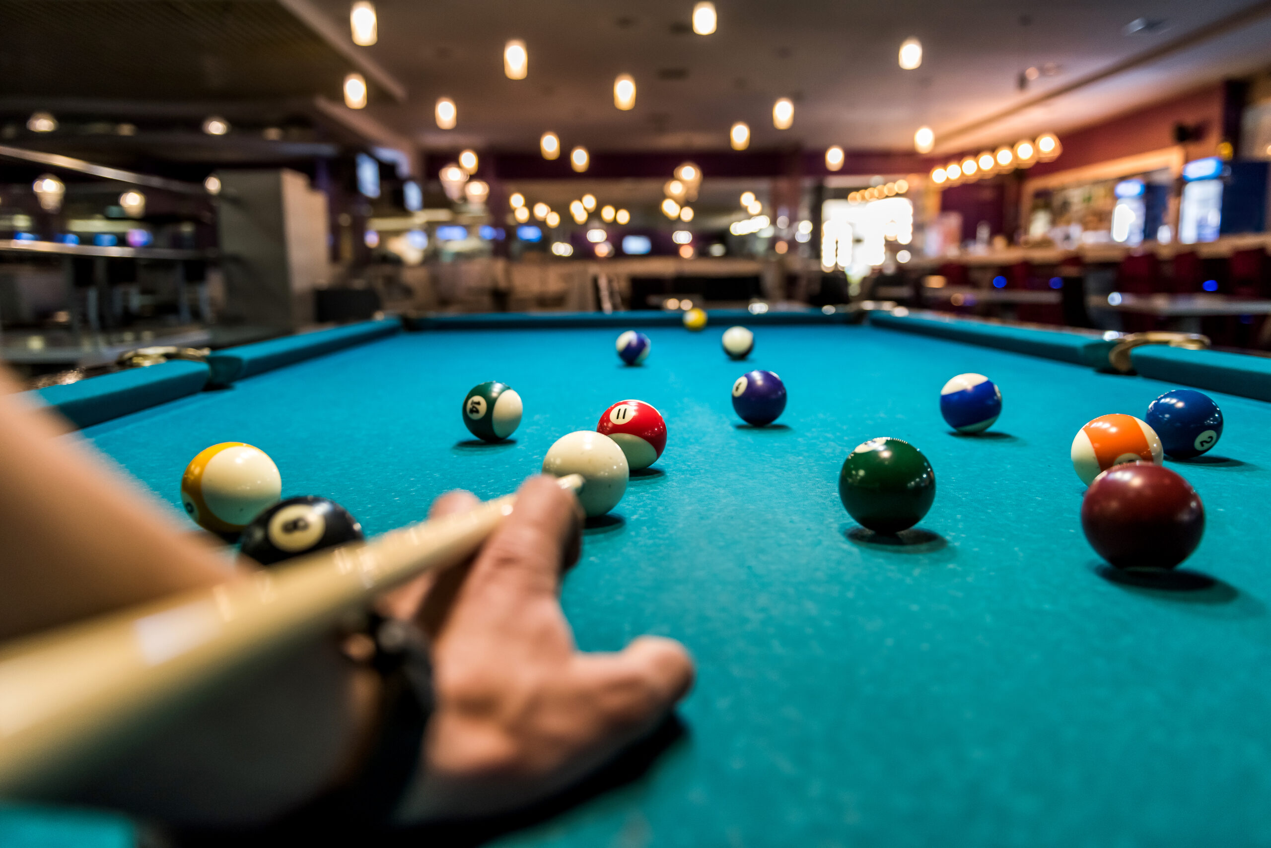 a man setting his billiard stick on a ball