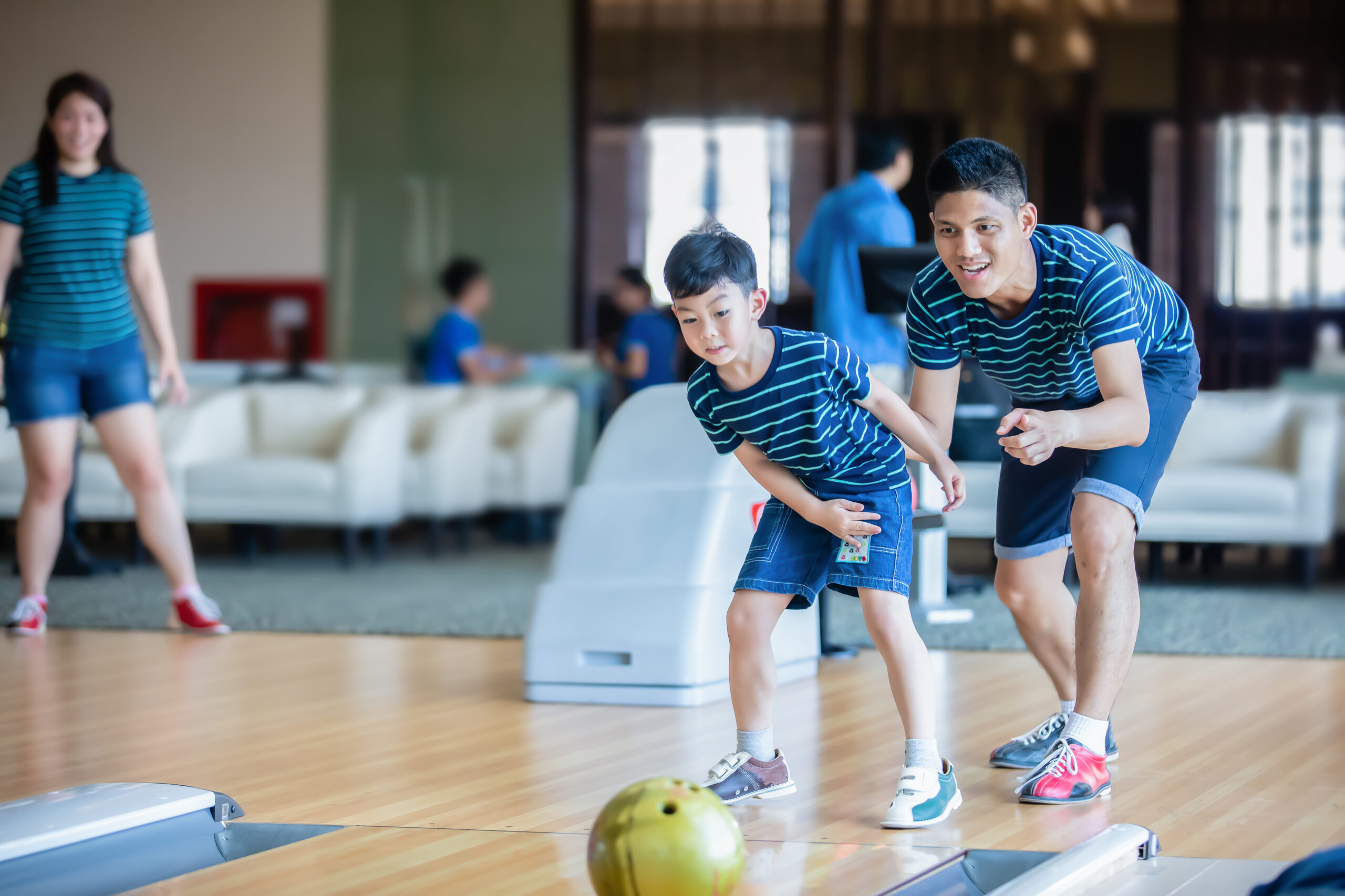 an older brother and younger playing bowling