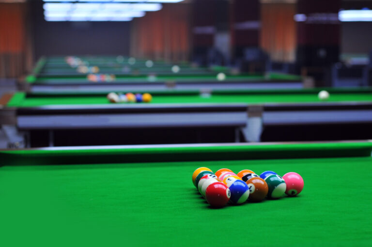 pool tables in parallel with billiard balls placed on top