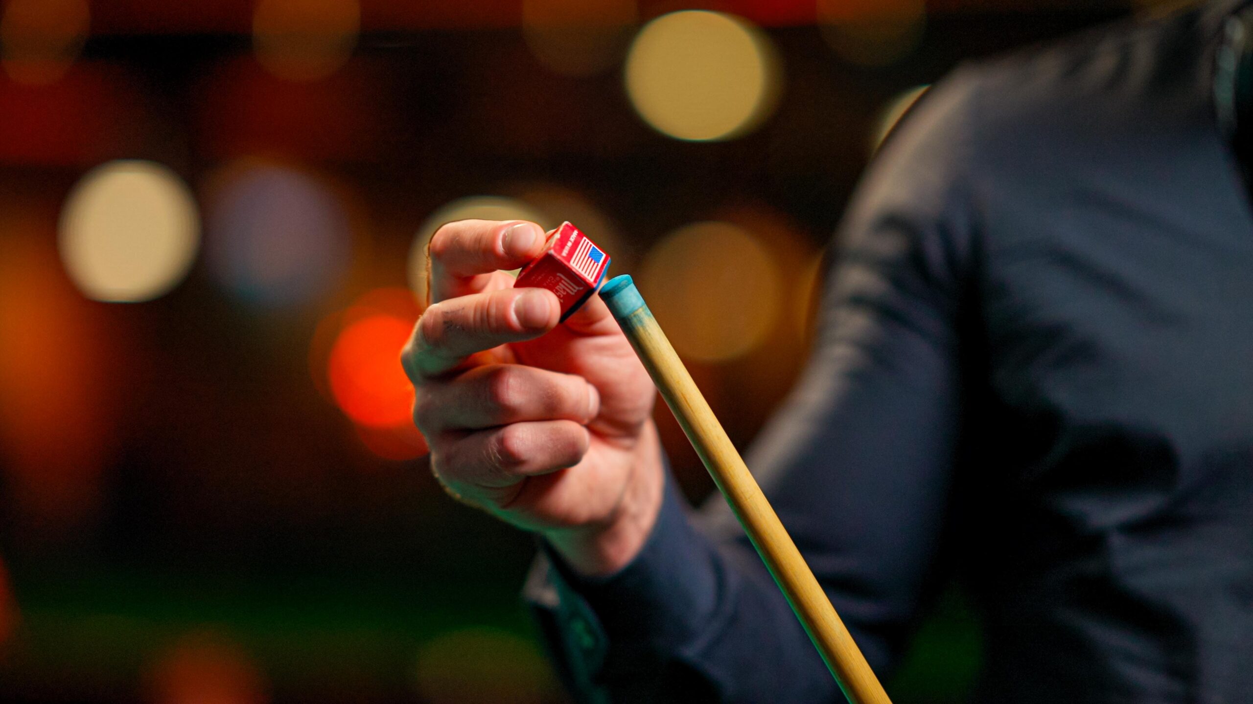 a woman player chalking her stick