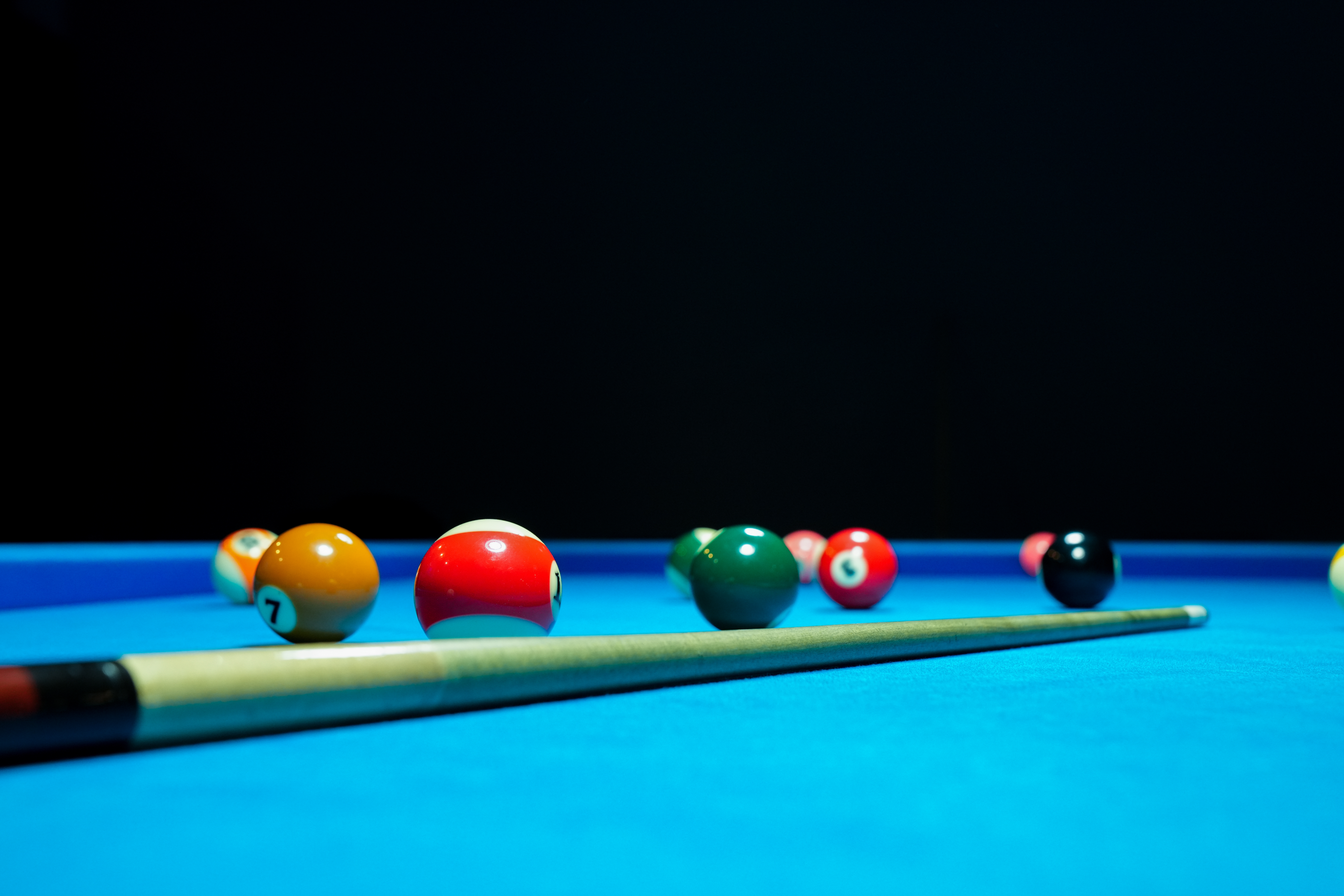 billiard balls and billiard stick on a pool table